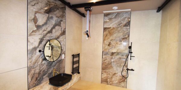 Luxury disability adapted wetroom. bespoke interior with marble walls and custom black ceiling hoist system.