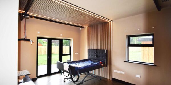 Bespoke disability adapted bedroom with custom black ceiling hoist track system and climate control.