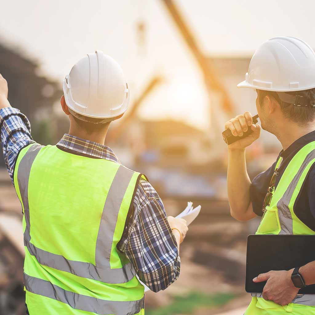 Architect in helmet on site with building contractor discussing an accessible project under construction