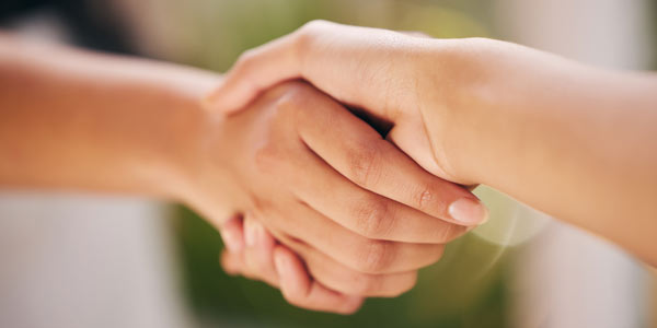 Close up of people shaking hands. Representative of the support provided to clients seeking accessible and adapted properties