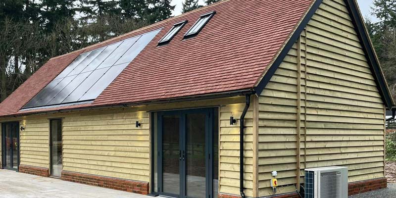 Accessible annexe building with solar panels and heat pump. Shown with wood cladding before it was darkened to blend with its heritage setting in Kent.