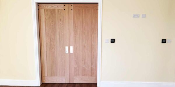 Double oak doors to accessible wetroom. Door widening and automated opening providing easy access for wheelchair users.